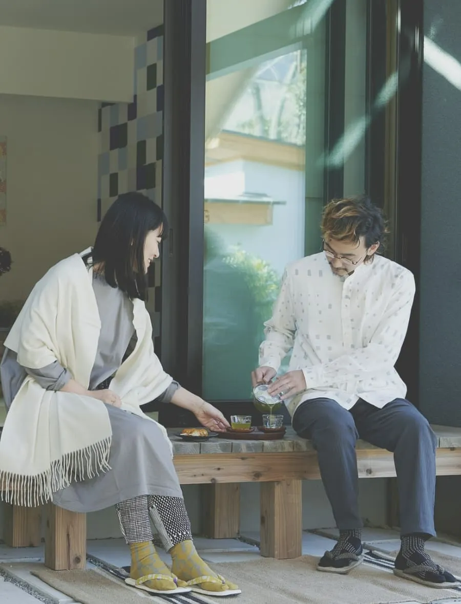 縁側でお茶を飲む夫婦の写真