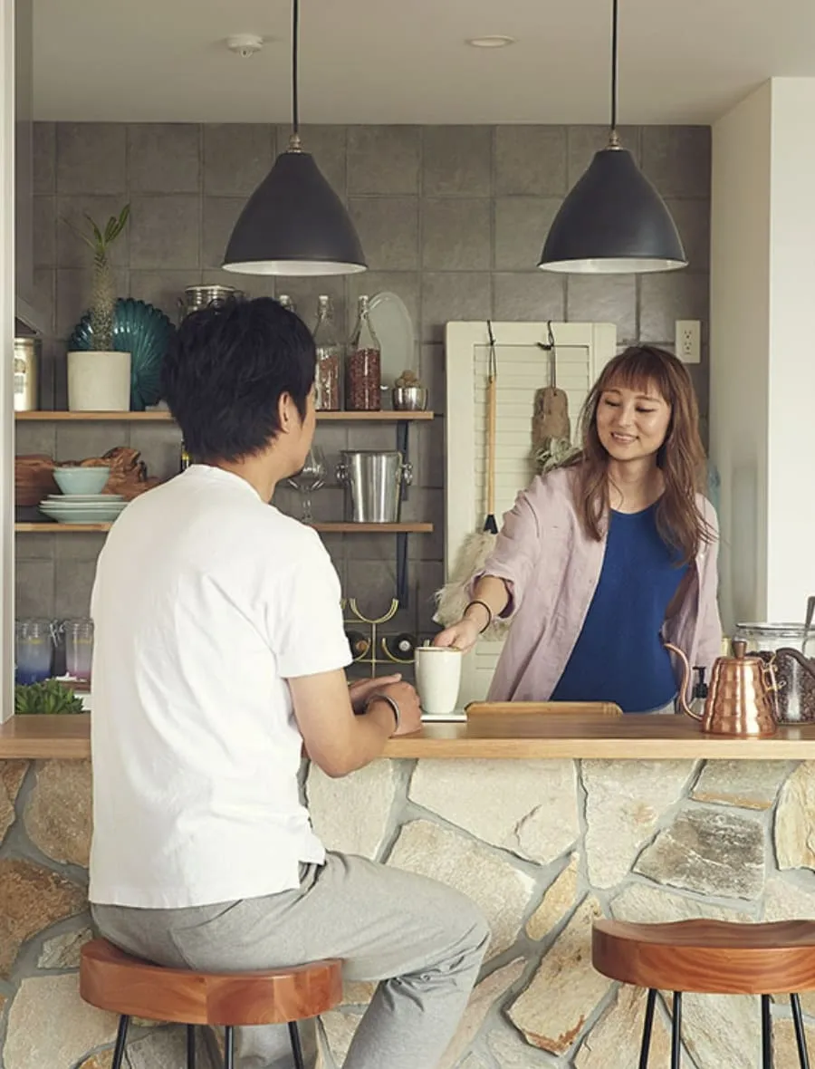 対面キッチンで話す夫婦の写真